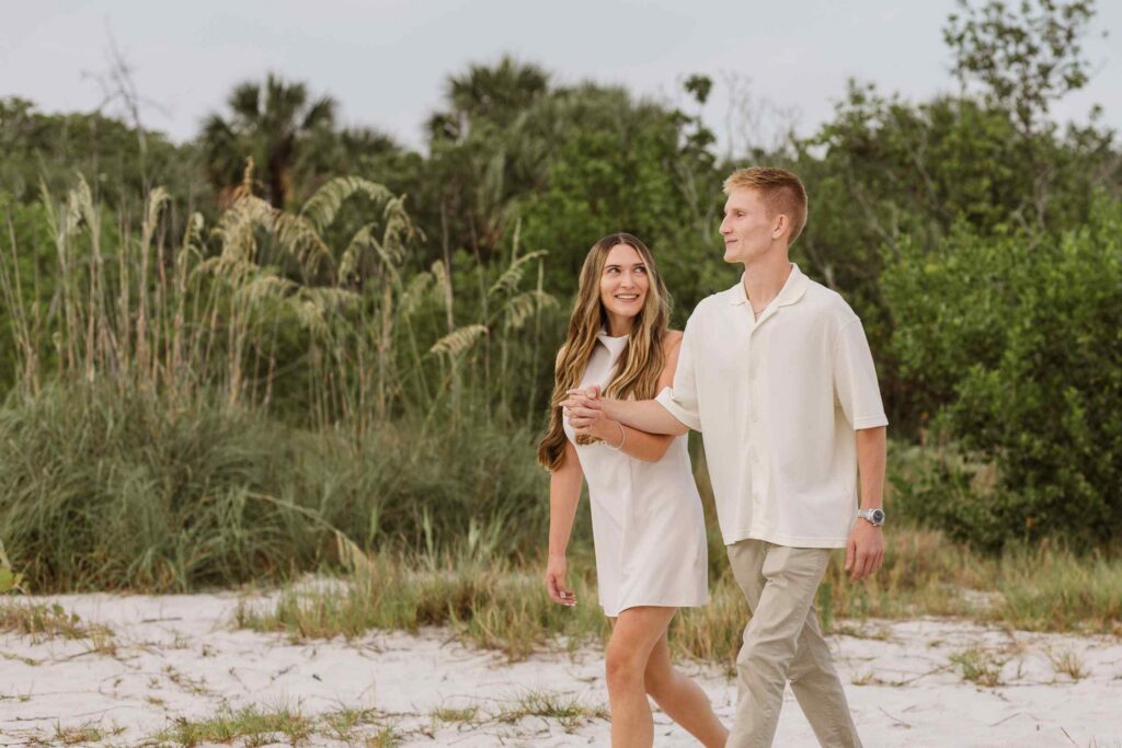 Couple walking through a path, the woman smiles up at the man while they hold hands