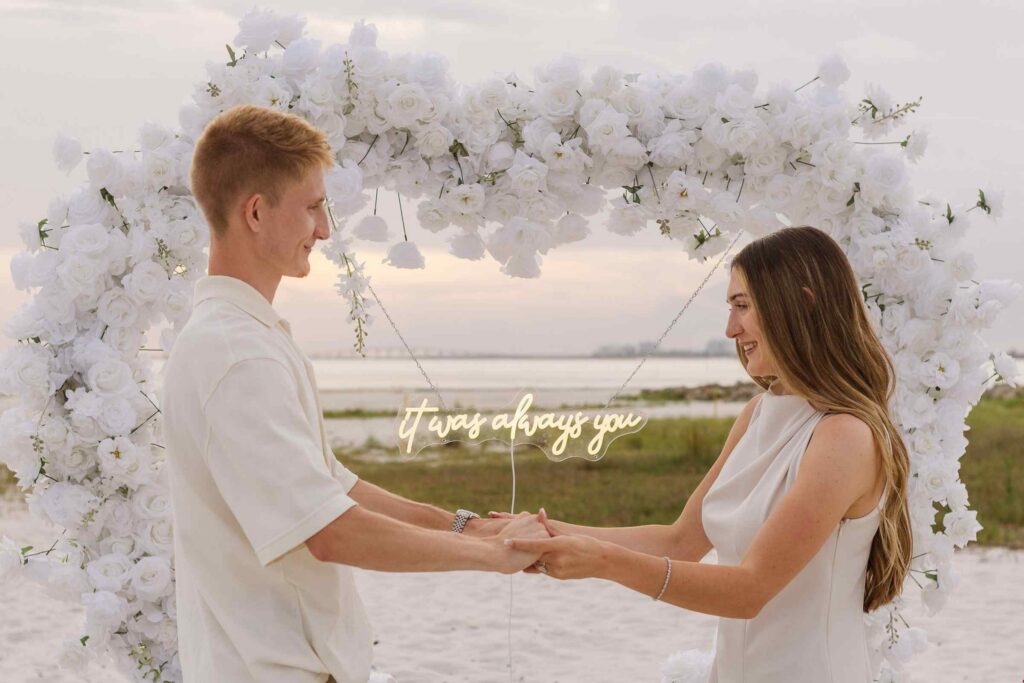 Couple holding hands with a sign in the middle that says "it was always you"